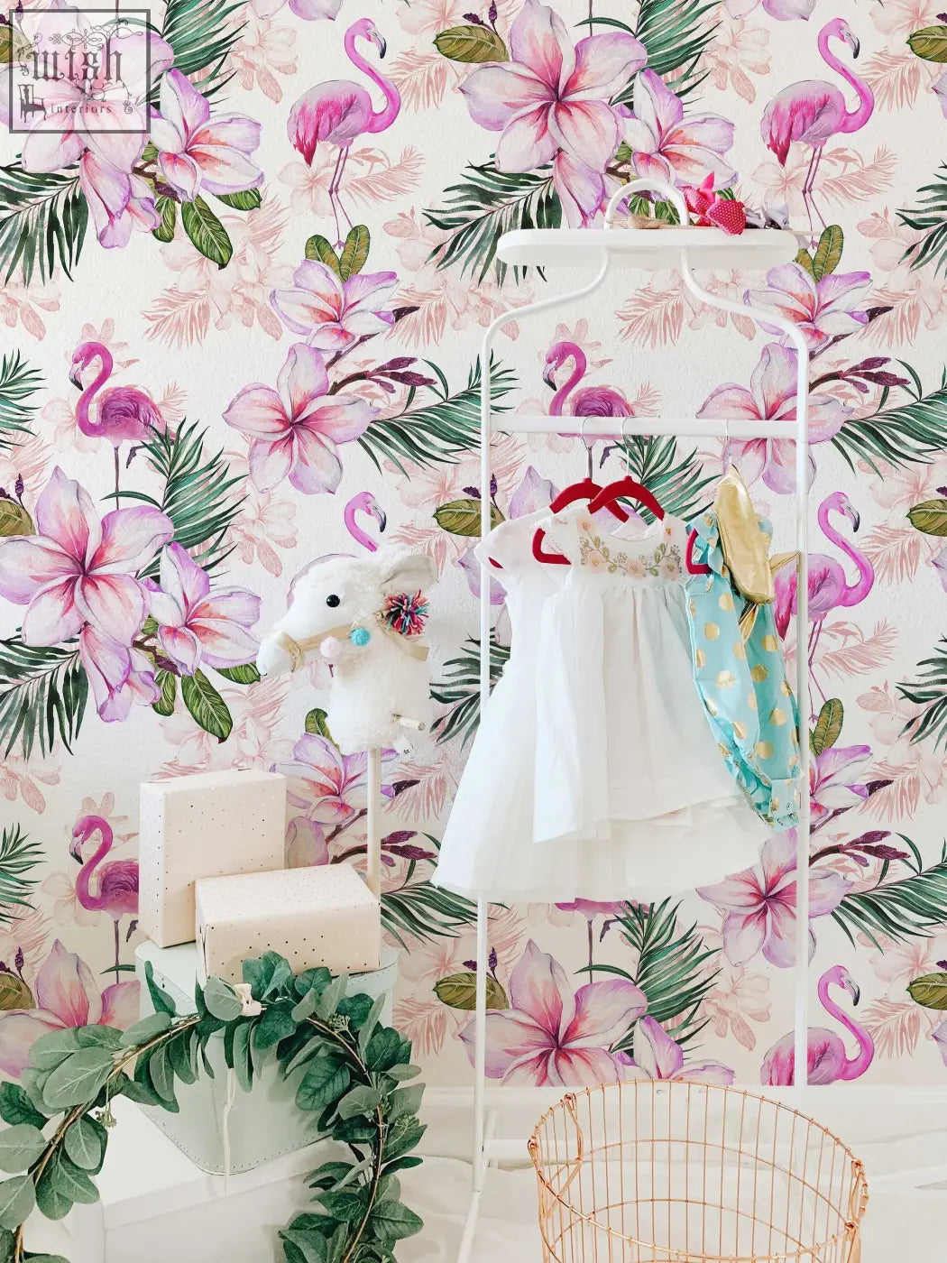 White children’s dress with ruffled skirt hanging next to pink flamingo floral traditional paper for pink nursery living space