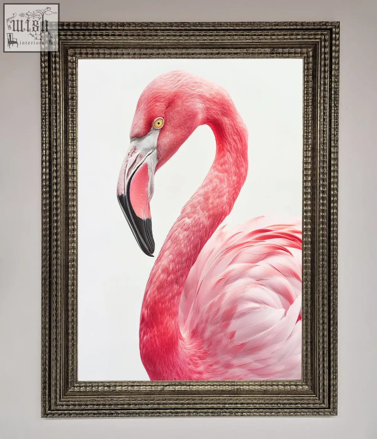 A framed print of a pink flamingo stare with detailed feathers and a black beak in an ornate silver-toned frame