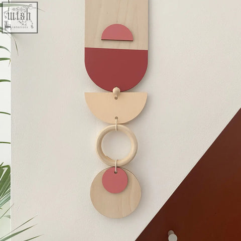 A minimalist wooden modern wall art with stacked geometric shapes in soft pink terracotta natural wood tones