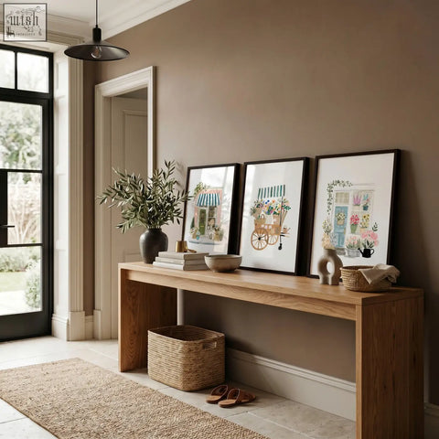 A sleek light oak console table with clean lines beneath pink picture flower shop botanical art prints set of 3