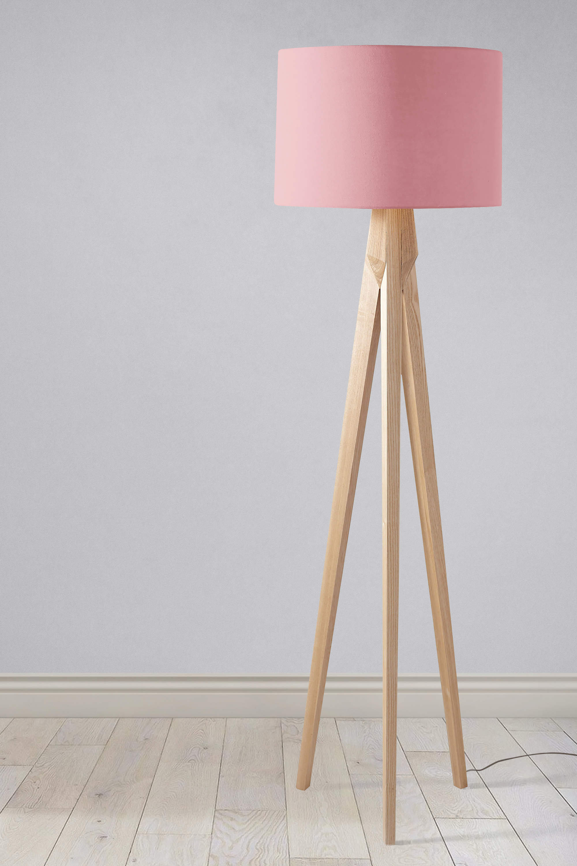 Minimalist tripod floor lamp with a plain dusty rose fabric lampshade and light wooden legs as a table lamp
