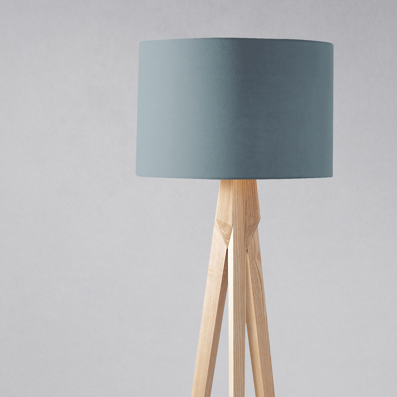 Minimalist table lamp with matte petrol blue lampshade and light wood tripod legs perfect for any room