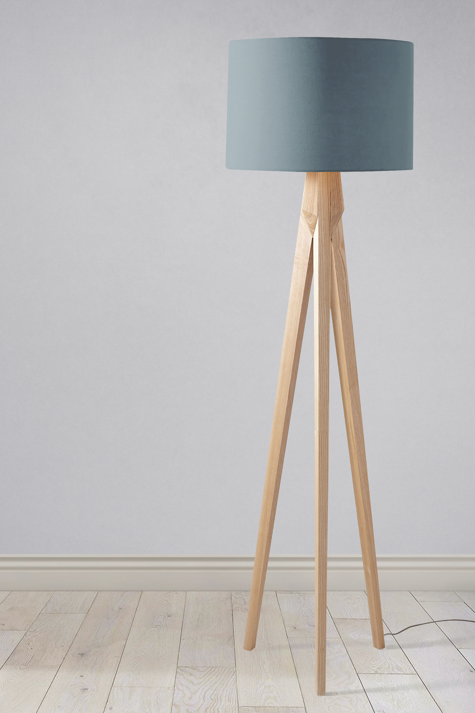Minimalist tripod floor lamp with plain petrol blue lampshade and light wooden legs perfect as a table lamp