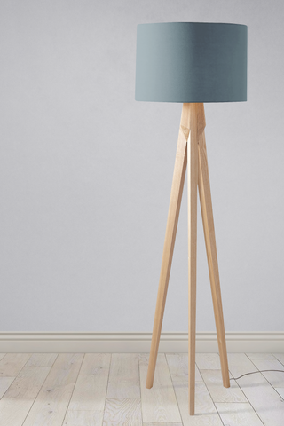 Minimalist tripod floor lamp with plain petrol blue lampshade and light wooden legs perfect as a table lamp