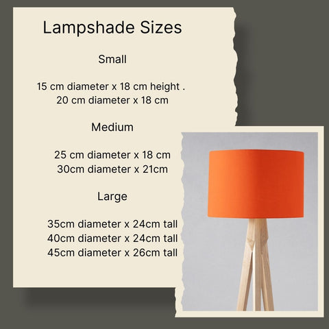 Vibrant plain yellow cylindrical table lamp with smooth fabric lampshade on light wooden tripod base