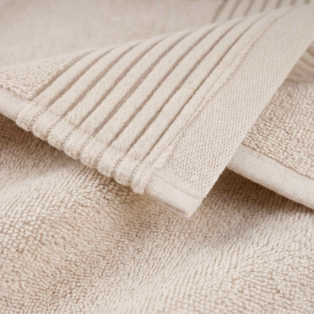Beige plush towels with ribbed edge and soft plush surface perfect for cozy bathroom use
