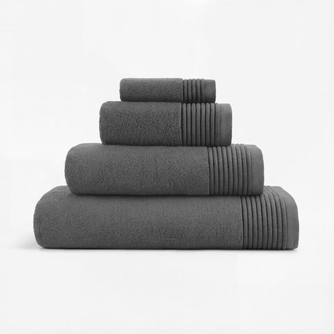 Set of four dark gray plush towels with ribbed edges neatly stacked for a soft and cozy bathroom essential