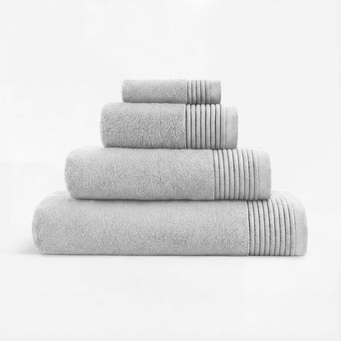Set of four neatly stacked gray plush towels with ribbed edge detail perfect for bathroom use