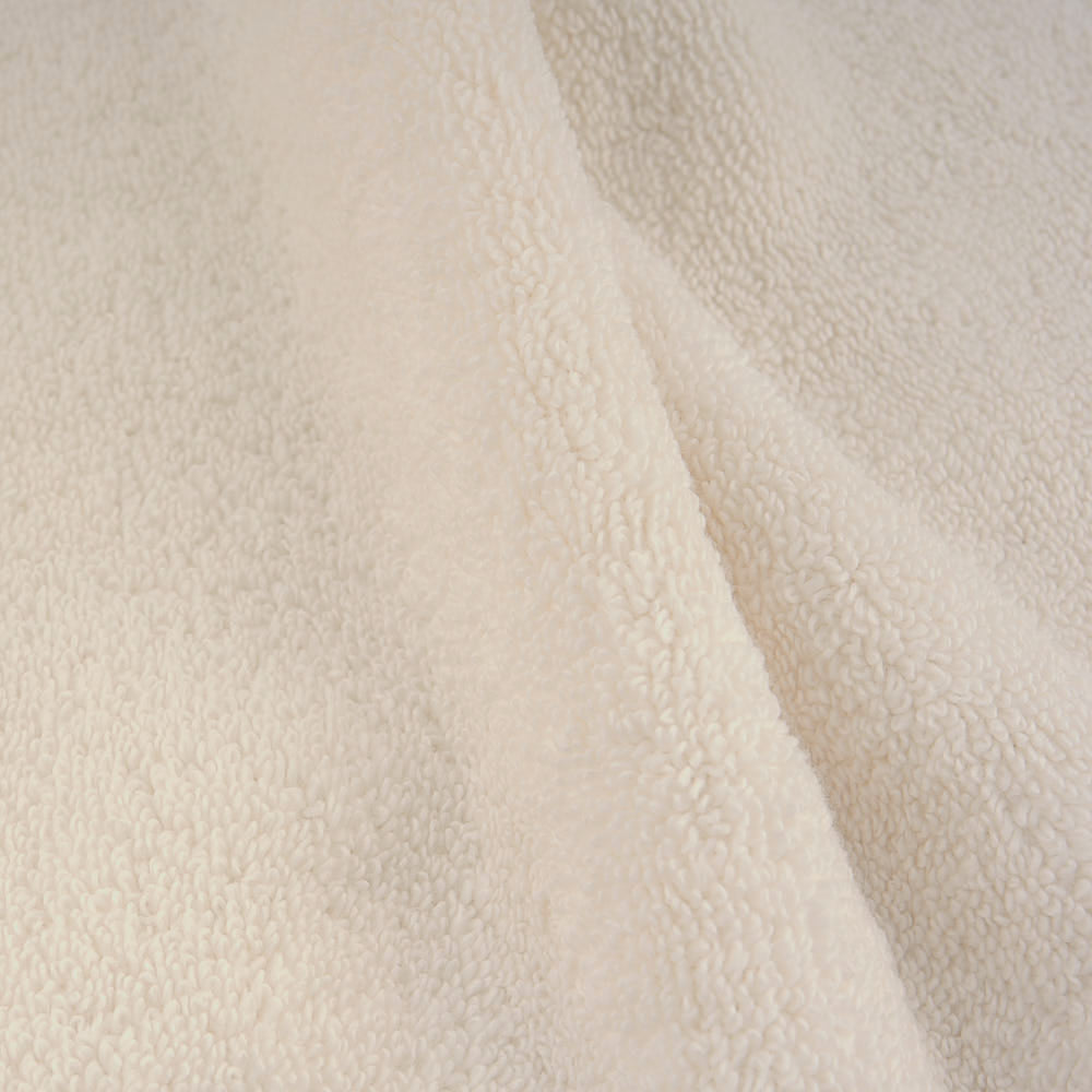Cream-colored plush towels set with soft textured surface made from cozy plush fabric for ultimate comfort