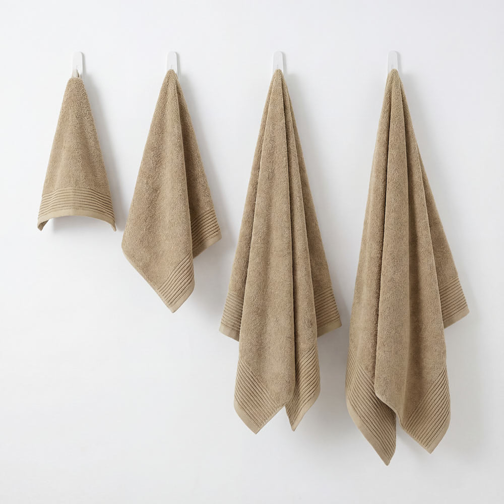 Set of four beige terry cloth hand towels with ribbed hemming from plush towels set for everyday use