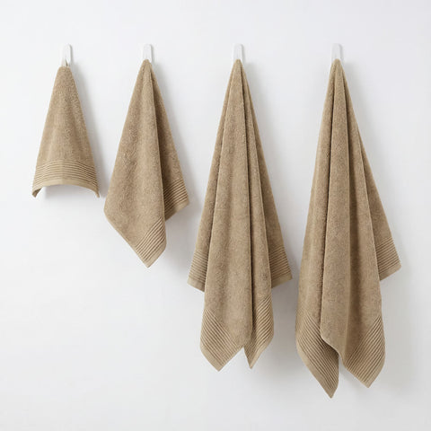 Set of four beige terry cloth hand towels with ribbed hemming from plush towels set for everyday use