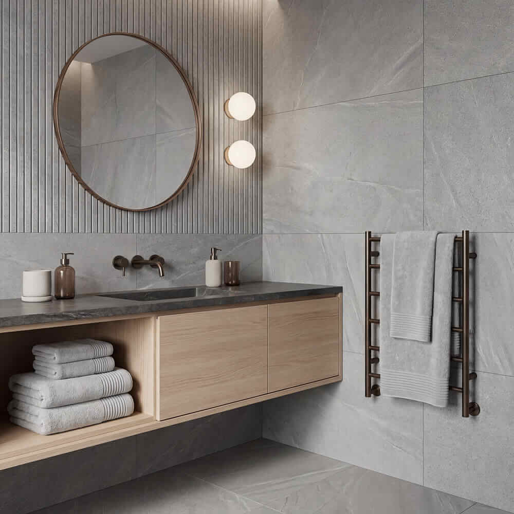 Modern round mirror with thin dark metal frame complementing plush towels set for stylish bathroom decor