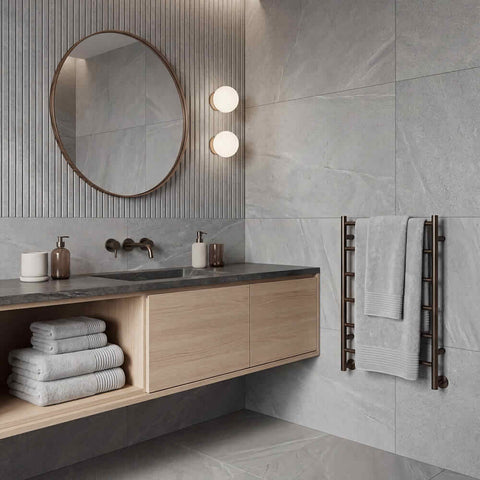 Modern round mirror with thin dark metal frame complementing plush towels set for stylish bathroom decor