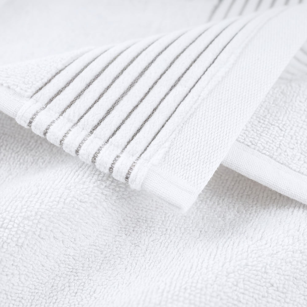 White plush towels set with soft textured surface and subtle gray striped edge for a cozy bathroom touch