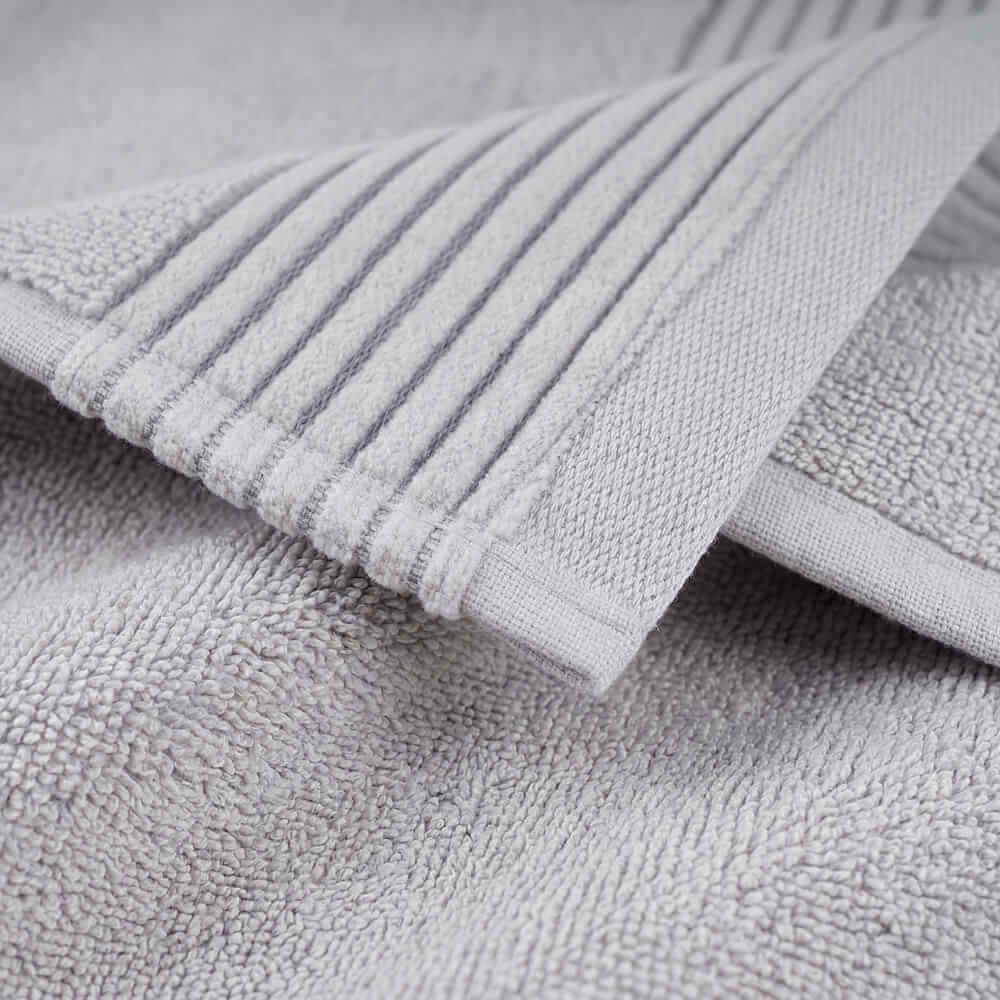 Soft gray terry cloth plush towel with ribbed edge detailing perfect for cozy bath use