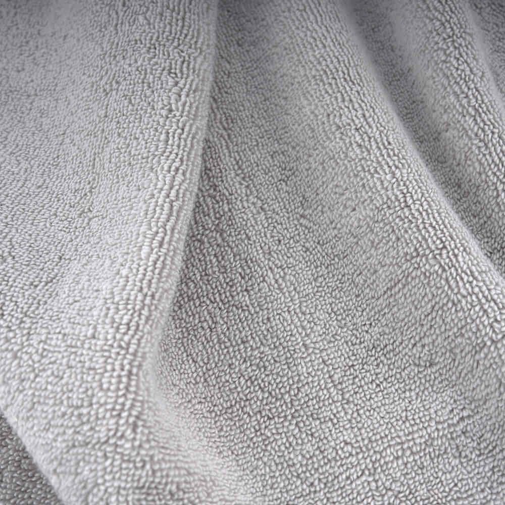 A soft light gray terry cloth towel with a plush textured surface perfect for plush towels collection