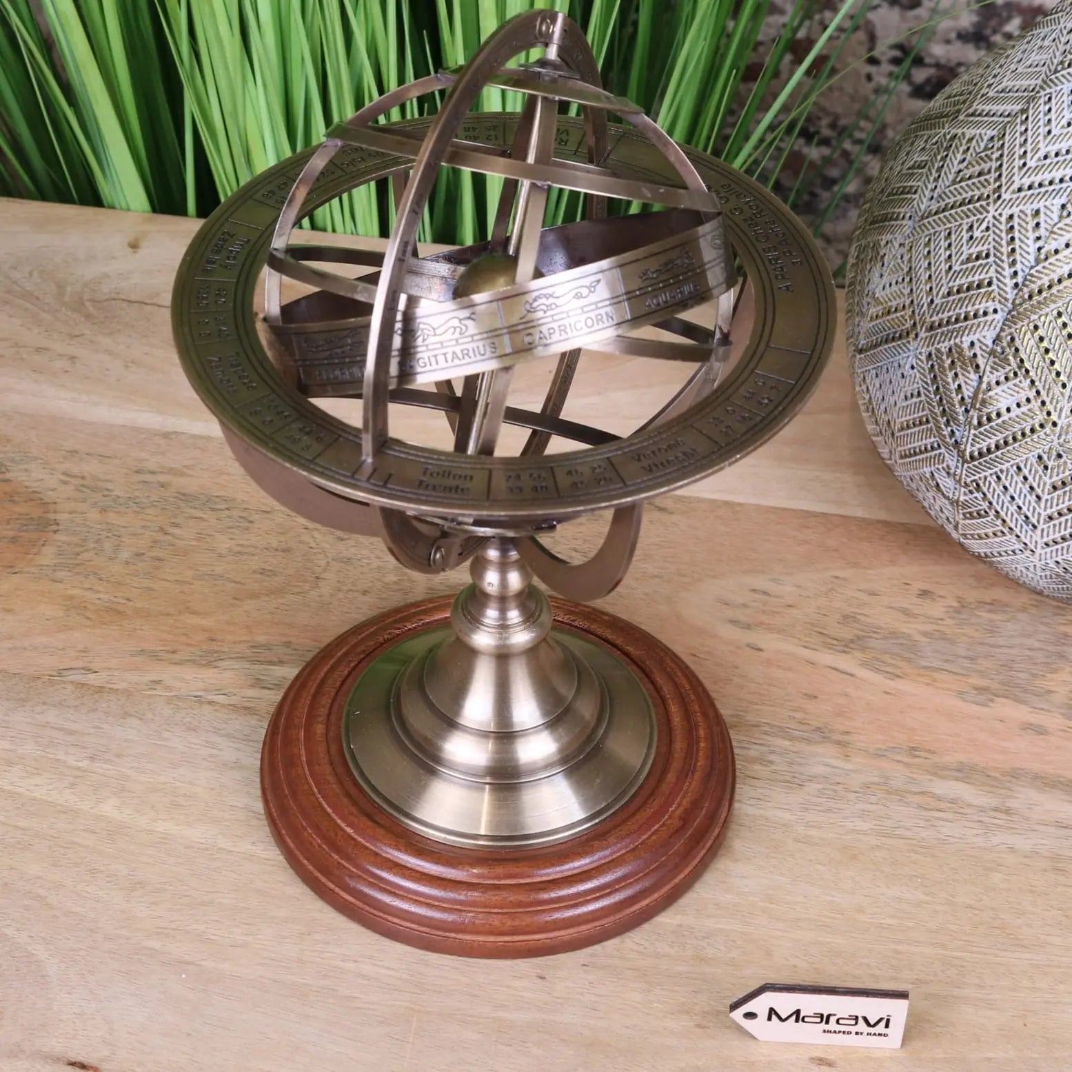 Antique-style brass armillary sphere with intricate zodiac markings on a polished wooden base 30cm size