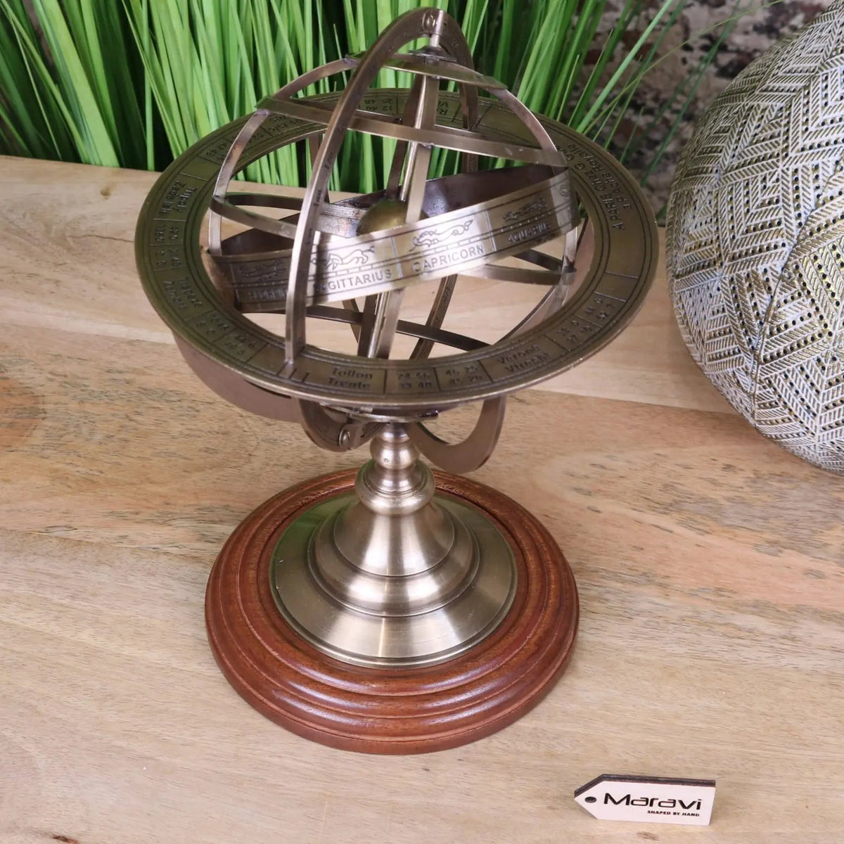 Antique-style brass armillary sphere with intricate zodiac markings on a polished wooden base 30cm size