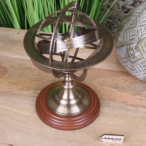 Antique-style brass armillary sphere with intricate zodiac markings on a polished wooden base 30cm size