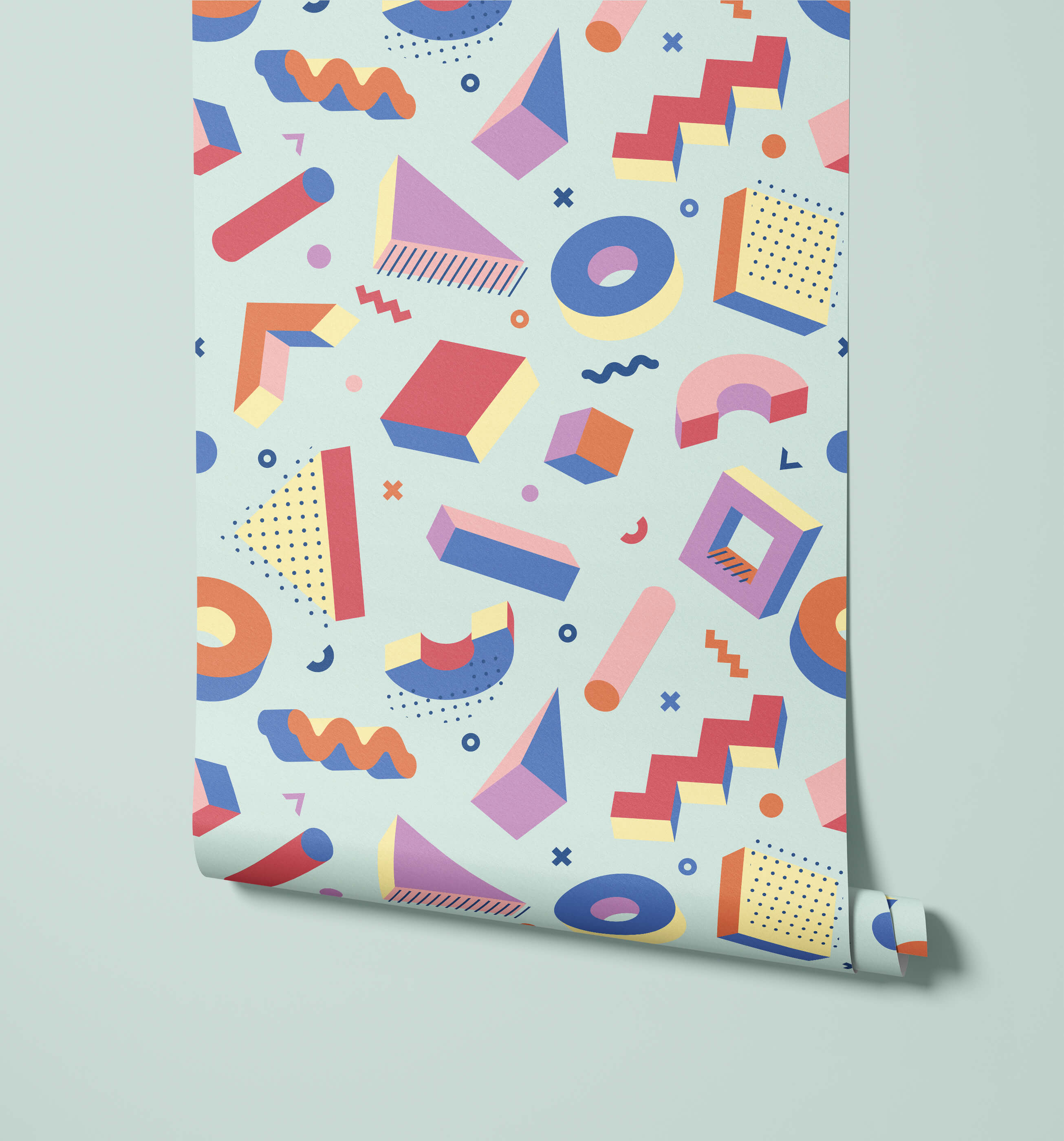 A roll of pop wallpaper with colorful geometric shapes in pink blue orange and yellow on a light mint background