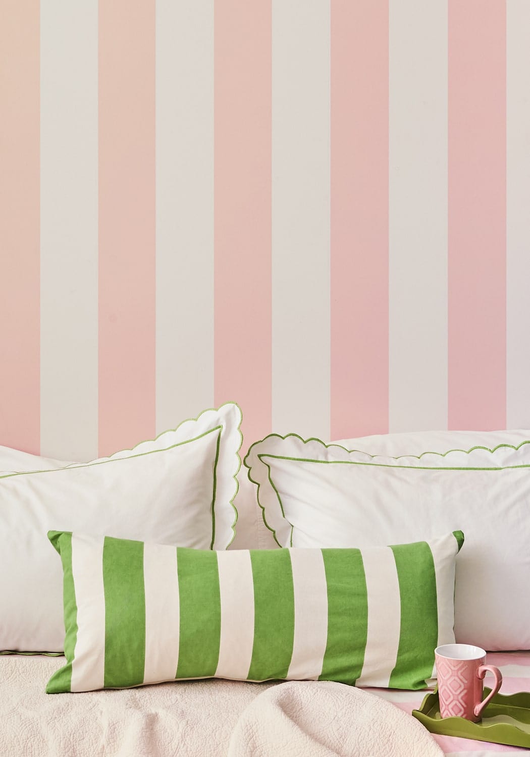 A vibrant green and white striped long lumbar cushion cover with scalloped edge from poppy sage cabana stripe collection