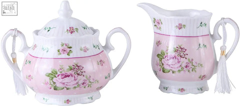 Pink floral ceramic sugar bowl with lid and tassel paired with matching cream milk jug in shabby chic vintage style