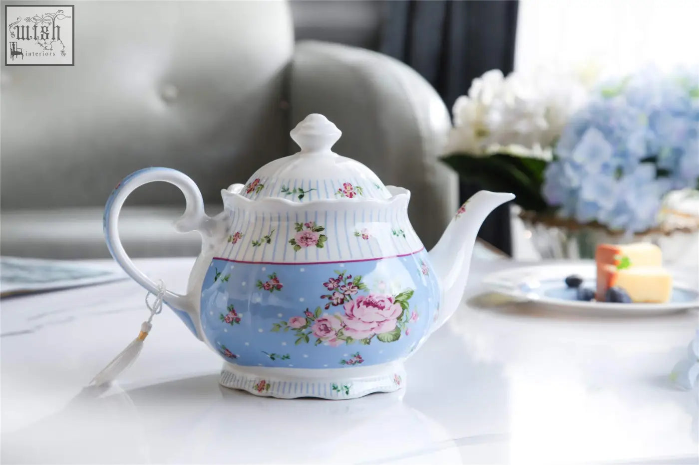A delicate porcelain teapot with blue floral design and white trim in a shabby chic teapot sugar bowl gift set