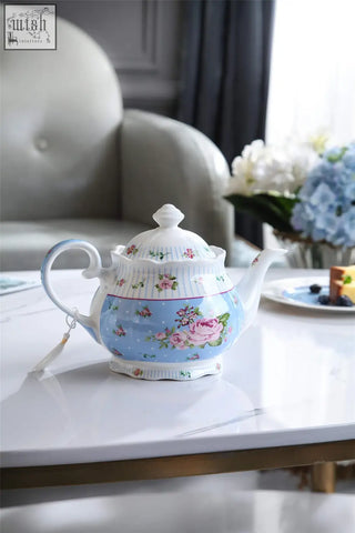 A delicate porcelain teapot sugar bowl set in light blue with pink floral patterns perfect for shabby chic gifts