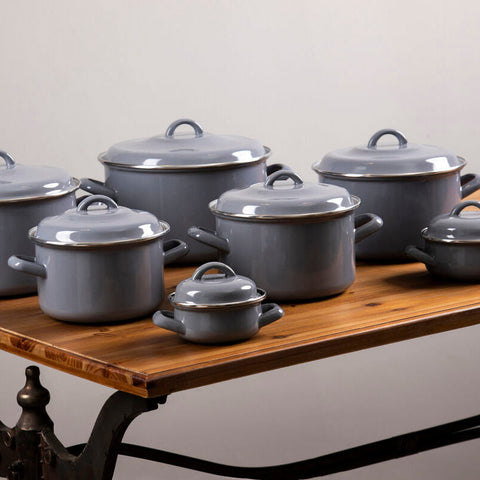 Set of porter grey enamel 22cm casserole dishes with matching lids and loop handles on a wooden table