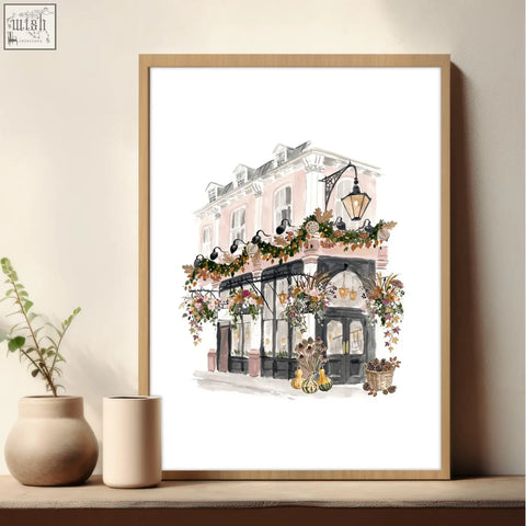 A framed watercolor poster art london print of a pink and black building with autumn garlands and pumpkins