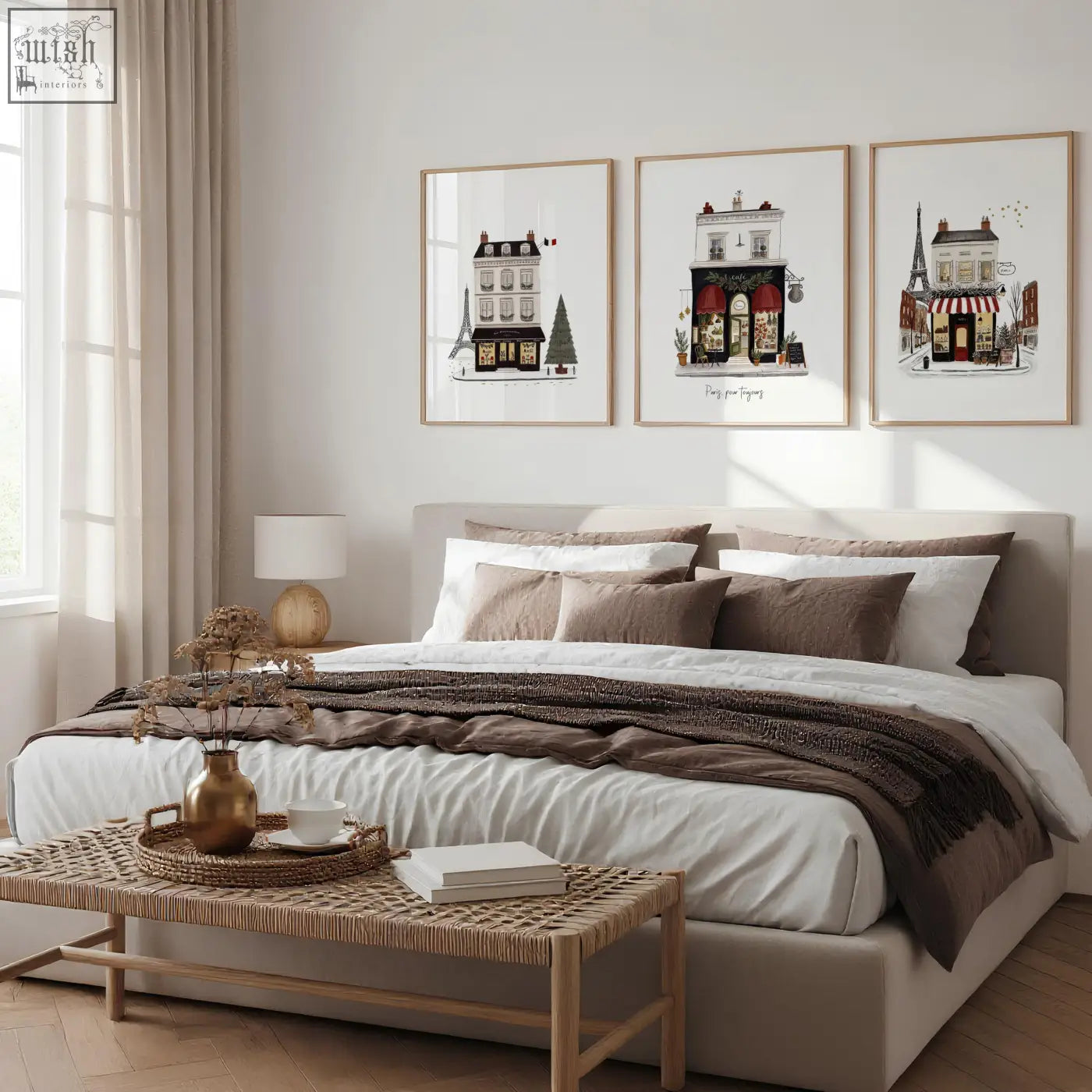 Beige upholstered bed with layered white and brown bedding next to street scenes pour toujours wall art set of 3
