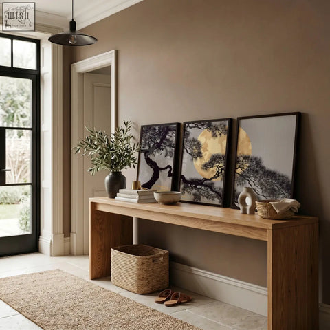 Three framed wall art prints featuring black and white japanese pine tree silhouettes with golden moon on wood table