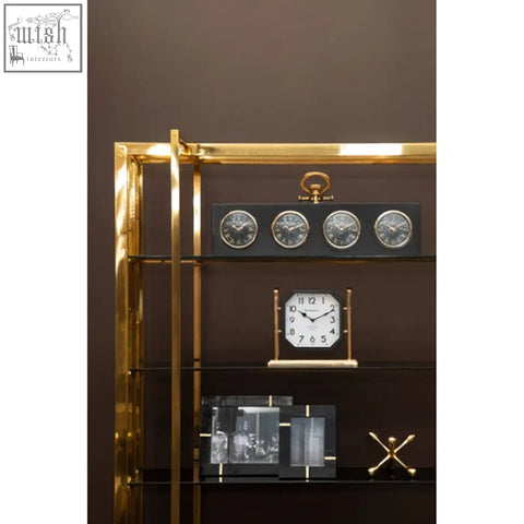 Gold finish prato jack sculpture with gold-framed rectangular clock and multiple smaller clocks on dark shelves