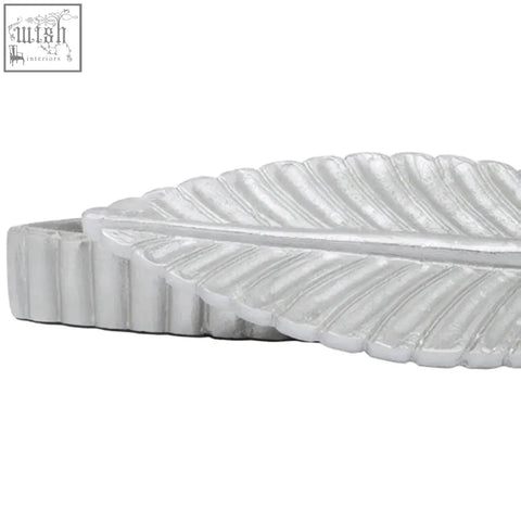 White leaf-shaped footstool with textured silver plume box surface and ridged edges in prato silver finish