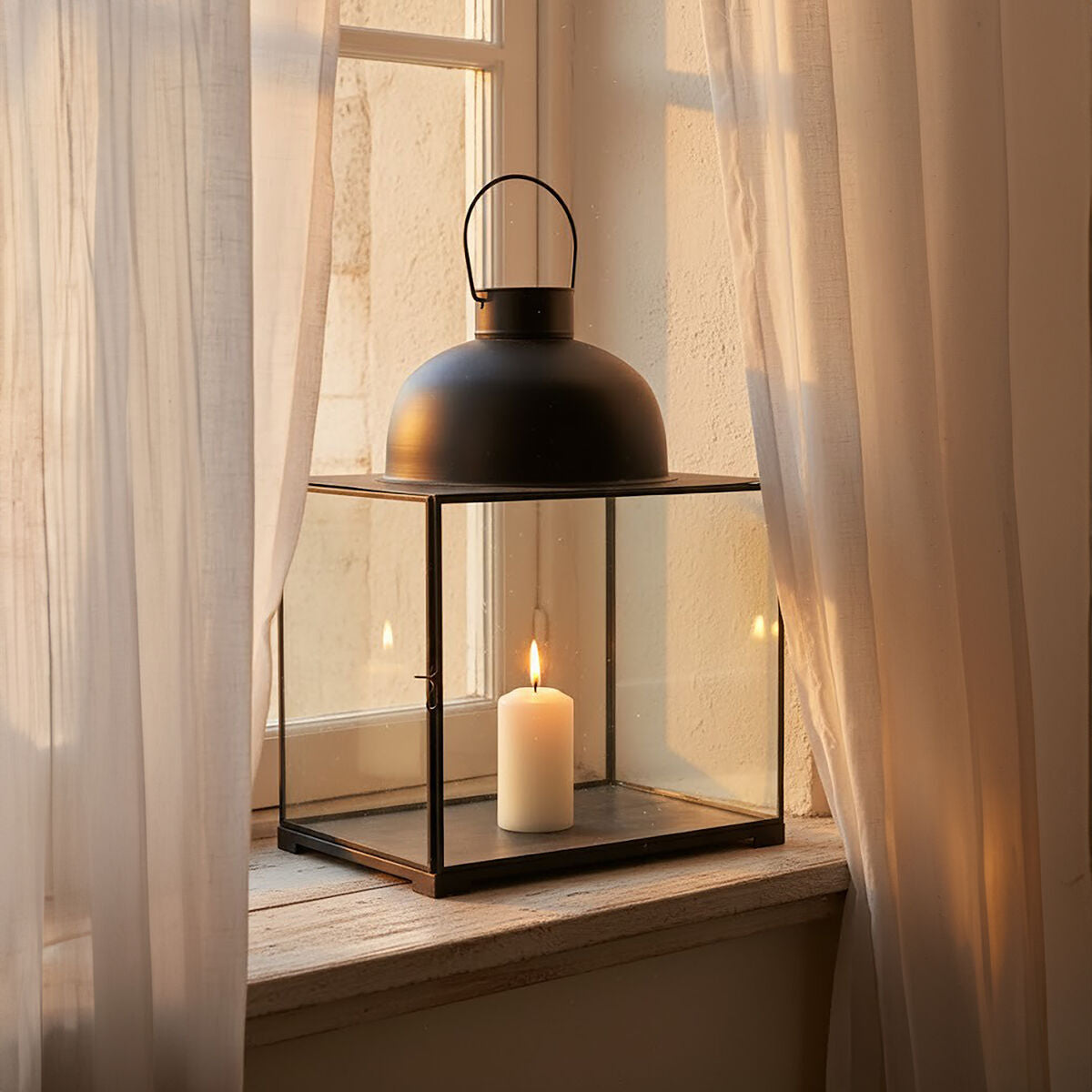Preston small antique black lantern with clear glass panels holding a lit white candle inside