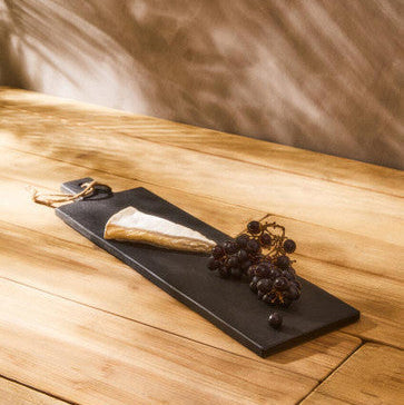 Black preto large slate paddle chopping board with white cheese wedge and dark grapes for serving and cutting