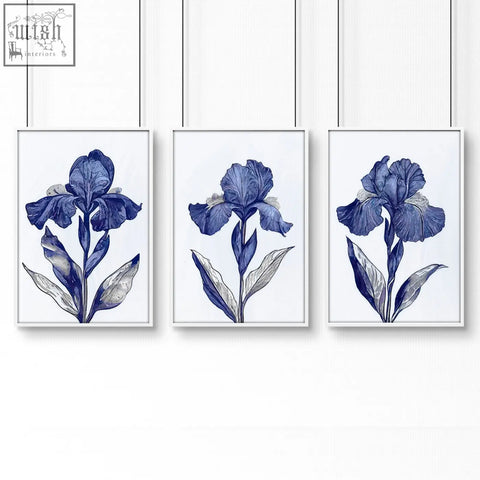 Set of three framed blue iris botanical wall art prints with white backgrounds and thin black hanging wires for bathroom