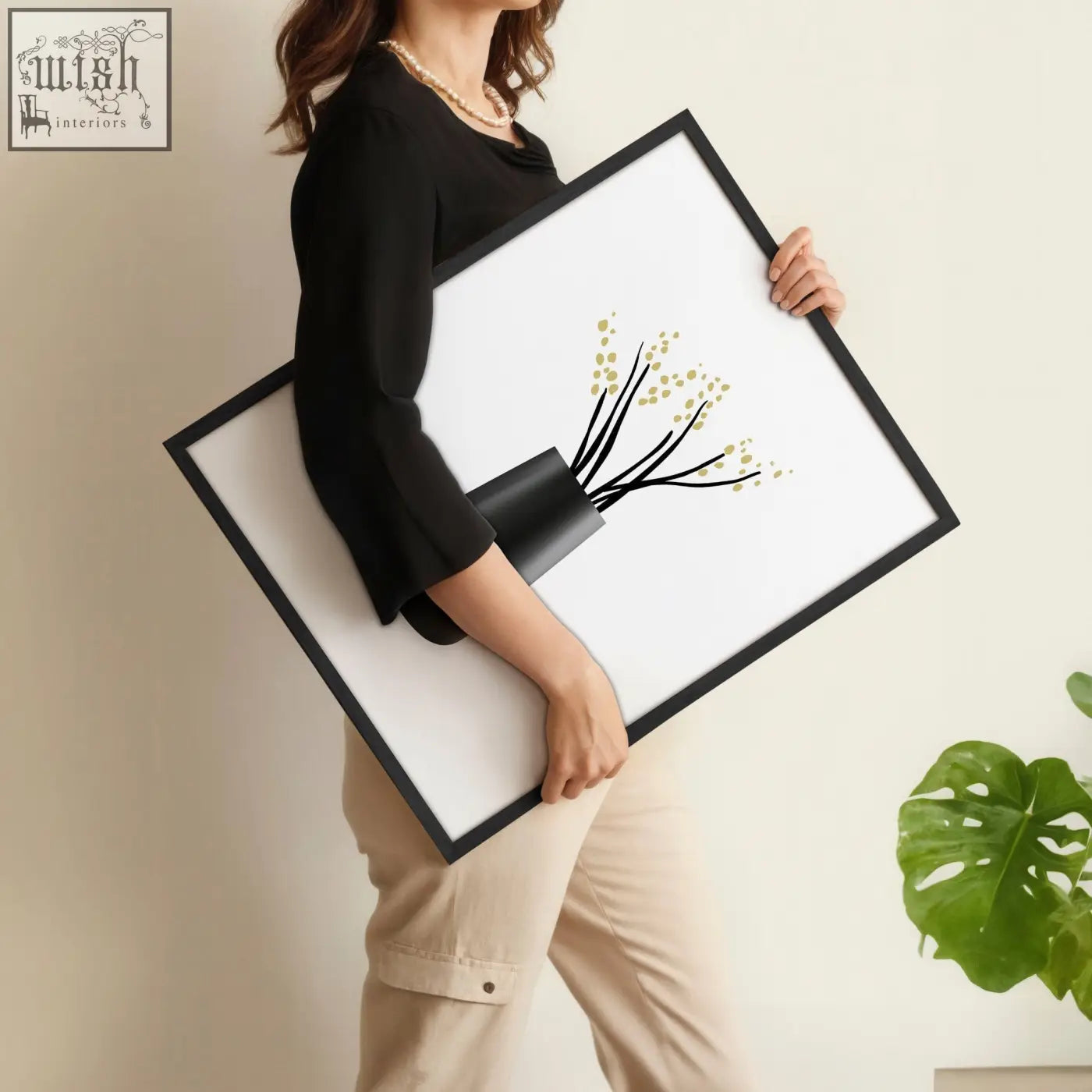 Black-framed minimalist botanical wall art prints featuring a stylized black vase with gold-green floral sprigs for bathroom walls