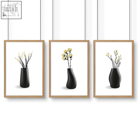 Set of three minimalist black ceramic vases with yellow blooms framed in light wood perfect botanical wall art for bathroom walls