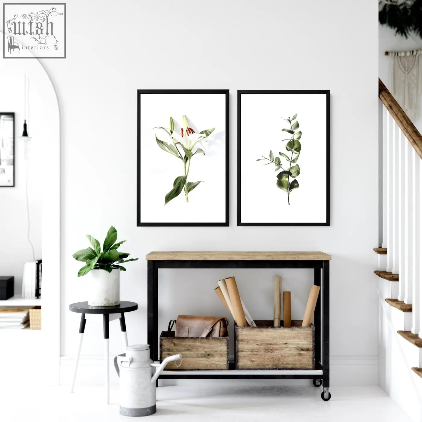 Two sleek black framed wall art prints featuring white lily and green eucalyptus botanical watercolor illustrations for kitchen