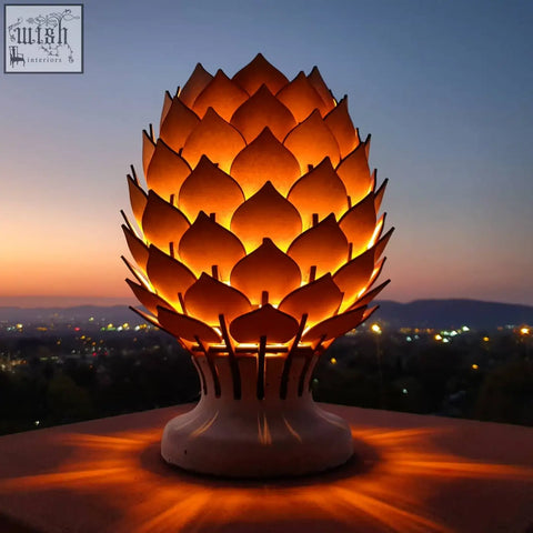 Warmly glowing protea table lamp with lotus-shaped translucent petals on a white ceramic base for cozy vibes