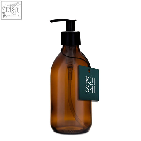 Amber glass pump bottle dispenser with black pump and dark green kui shi logo tag for easy dispensing