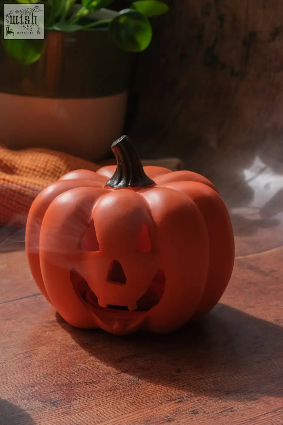 Orange plastic halloween pumpkin incense cone burner with carved face and black stem for cone burner use