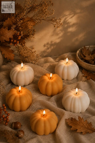 Six lit pumpkin shaped candles in warm orange and creamy white wax with a smooth glossy finish perfect for pumpkin spice decor
