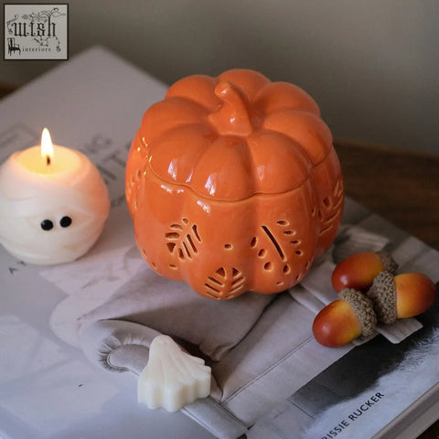 Orange ceramic pumpkin wax melt burner with leaf cutouts perfect for fragrance oil and pumpkin spice scents