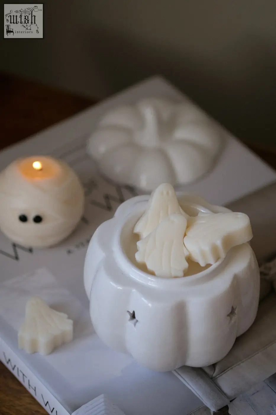 White ceramic pumpkin wax melt burner with star cutouts and white tree-shaped wax melts for pumpkin spice fragrance oil