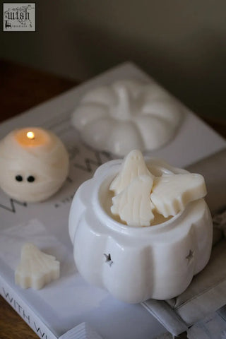 White ceramic pumpkin wax melt burner with star cutouts and white tree-shaped wax melts for pumpkin spice fragrance oil