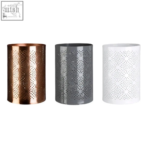 Three perforated cylindrical candle holders in copper grey and white including a grey candle holder