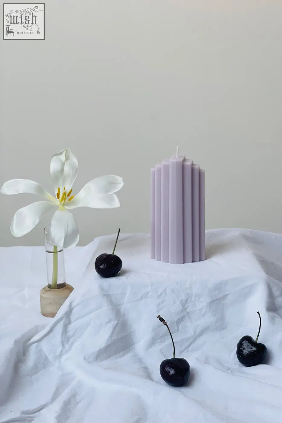 A tall lavender pyramid sculpted candle with vertical ridges perfect for home decor and ambiance