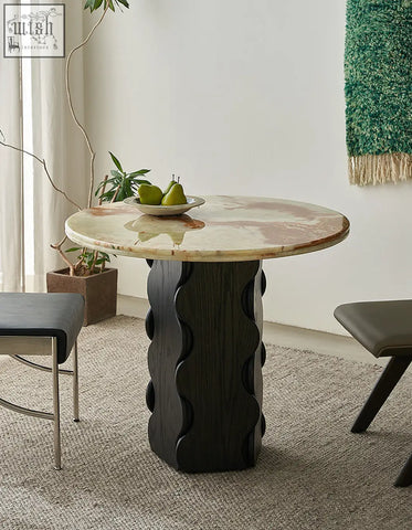 Quintero dining table round with a round marble top in beige swirls and a dark solid wood option base with wavy grooves
